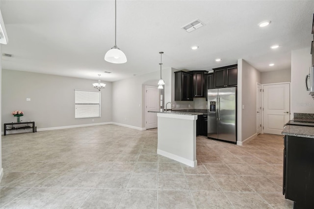 kitchen with stainless steel appliances, stone counters, light tile patterned floors, sink, and decorative light fixtures