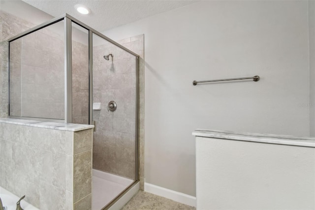 bathroom with a textured ceiling, tile patterned flooring, and an enclosed shower