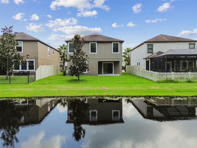 back of house with a water view and a yard