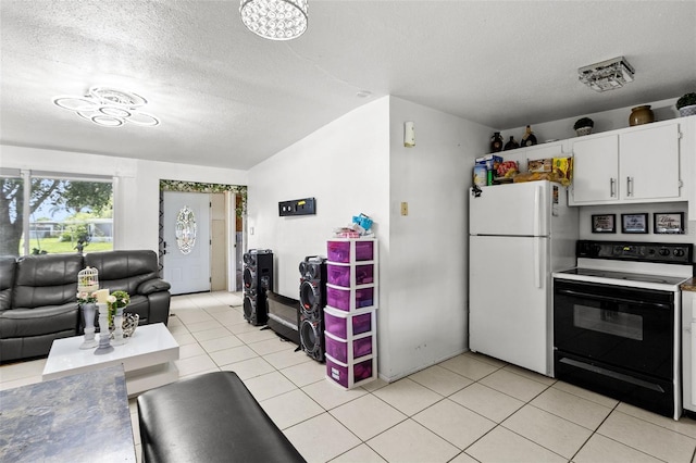 kitchen with white appliances, a textured ceiling, white cabinetry, and light tile patterned flooring