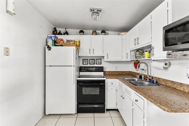 kitchen with a textured ceiling, white appliances, light tile patterned floors, sink, and white cabinetry