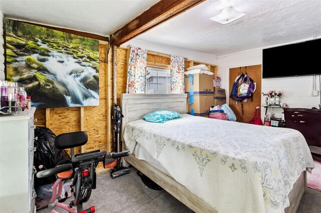 bedroom with wood walls, a textured ceiling, beamed ceiling, and carpet floors