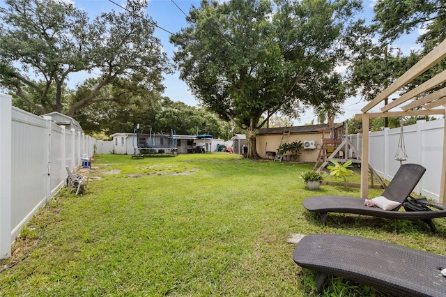 view of yard with a storage shed and a trampoline