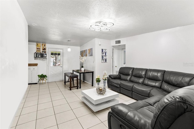 tiled living room featuring a textured ceiling