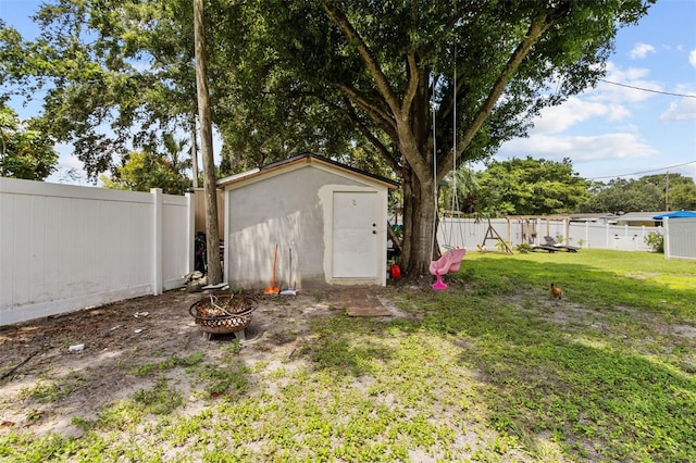 view of yard with a storage unit and an outdoor fire pit