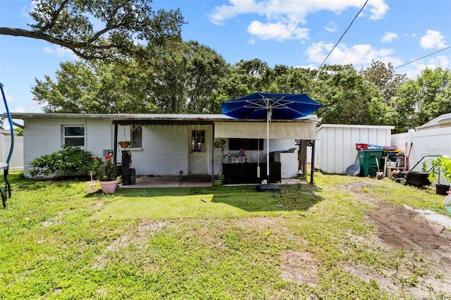 back of property featuring a storage shed and a lawn