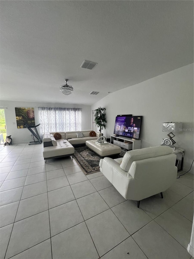 living room featuring a textured ceiling, light tile patterned floors, and plenty of natural light