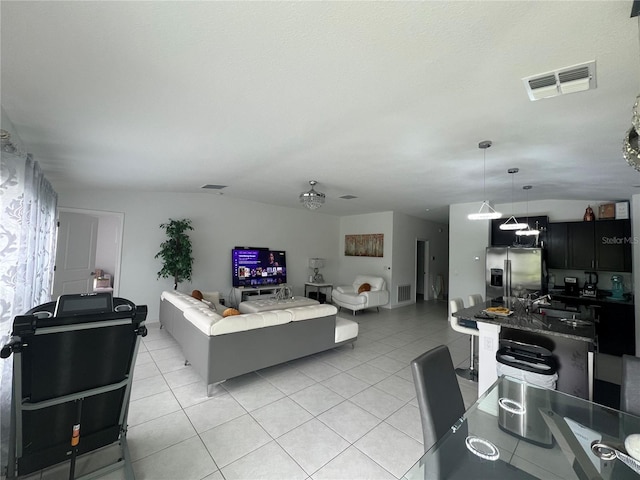 living room featuring vaulted ceiling and light tile patterned floors