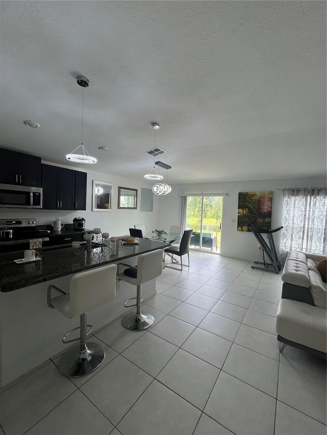 living room with sink, a textured ceiling, and light tile patterned floors