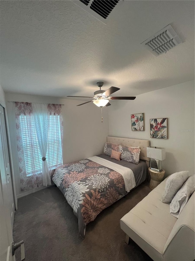 carpeted bedroom featuring a textured ceiling and ceiling fan