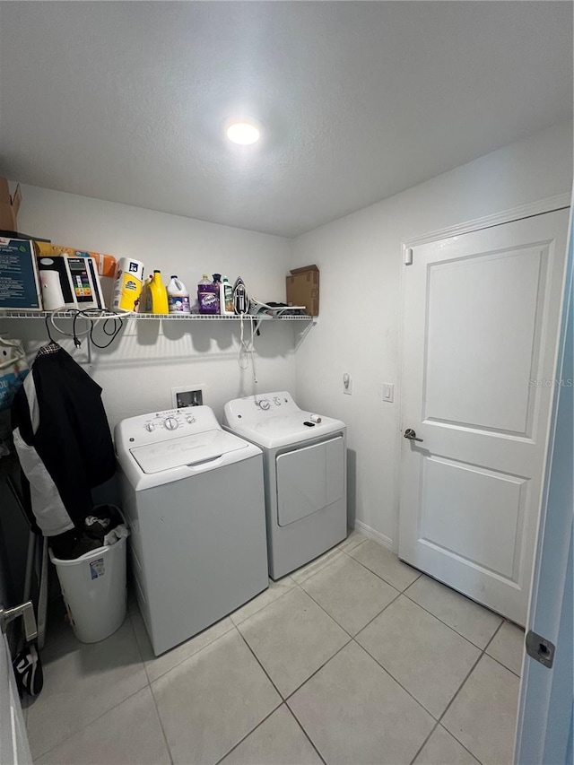 laundry area with separate washer and dryer and light tile patterned floors