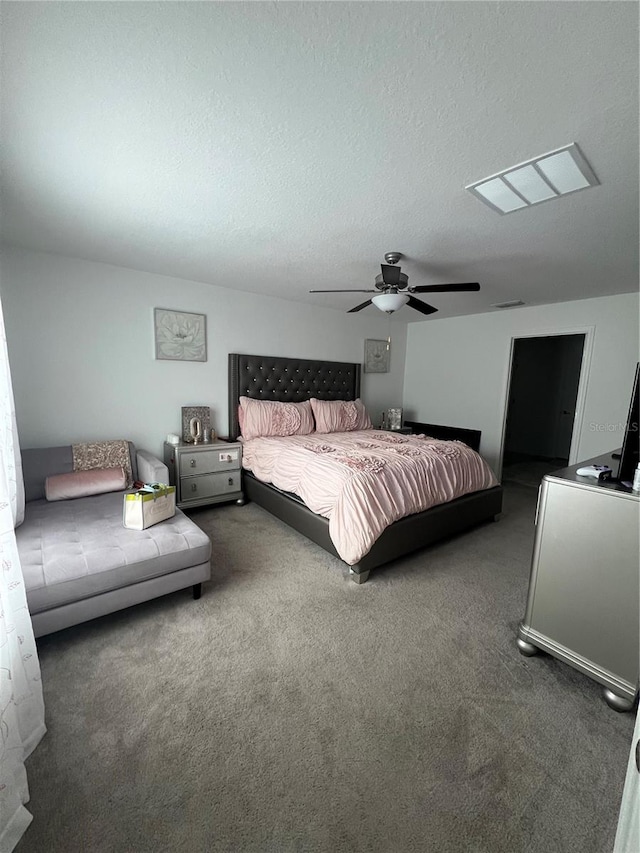 carpeted bedroom featuring a textured ceiling and ceiling fan