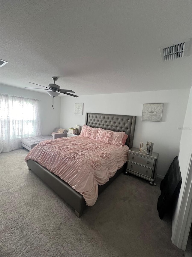 bedroom featuring dark carpet, a textured ceiling, and ceiling fan