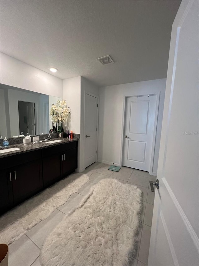 bathroom with vanity, a textured ceiling, and tile patterned floors