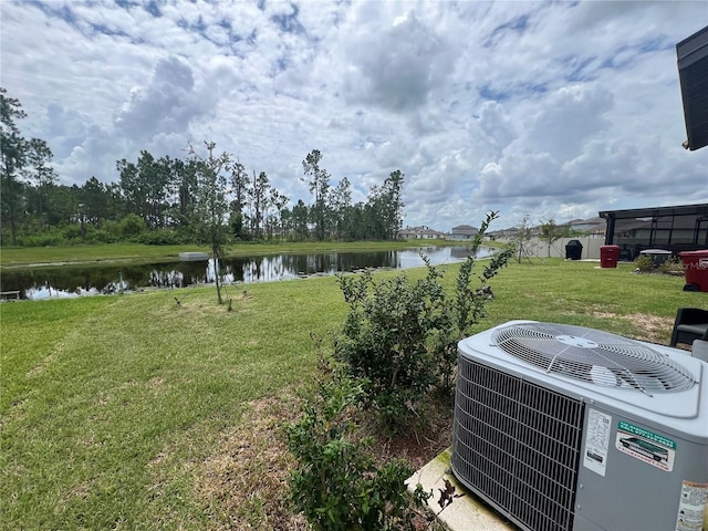 view of yard with central air condition unit and a water view