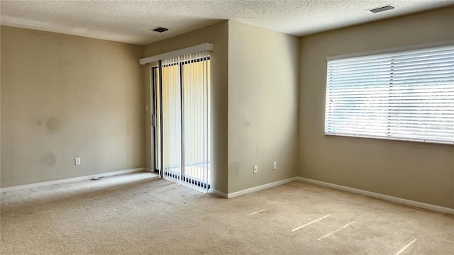 carpeted spare room featuring a textured ceiling