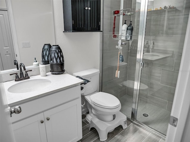 full bathroom featuring toilet, a shower stall, and vanity