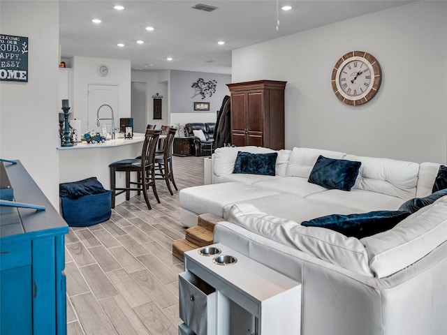 living area featuring wood finish floors, visible vents, and recessed lighting