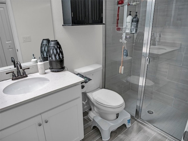 full bathroom with a shower stall, toilet, and vanity