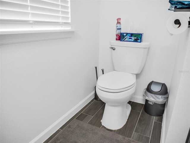 bathroom featuring toilet, wood tiled floor, and baseboards