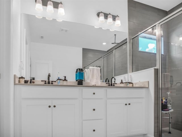 full bath with visible vents, a shower stall, and double vanity