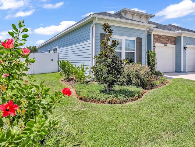 view of property exterior with a garage, a yard, and fence