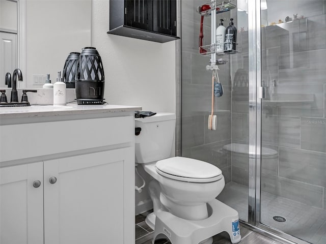 full bath featuring toilet, a shower stall, and vanity