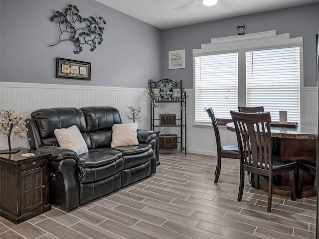 living area featuring wood finish floors and a wainscoted wall