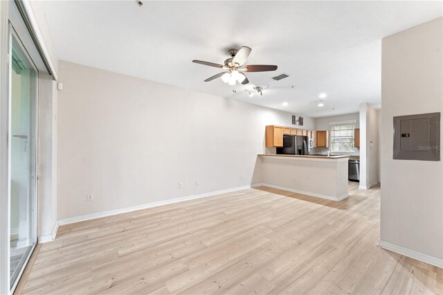 unfurnished living room featuring electric panel, light hardwood / wood-style flooring, and ceiling fan