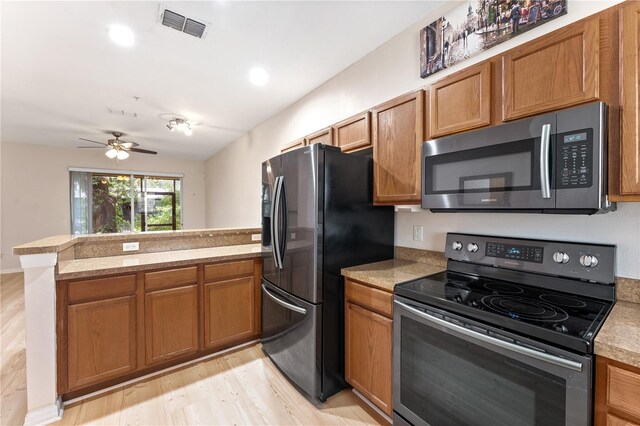 kitchen with ceiling fan, appliances with stainless steel finishes, kitchen peninsula, and light hardwood / wood-style floors