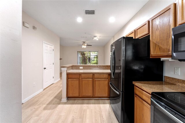 kitchen featuring ceiling fan, kitchen peninsula, black fridge, light hardwood / wood-style floors, and electric range