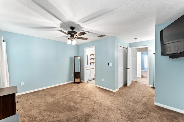 empty room featuring ceiling fan, a textured ceiling, and light carpet