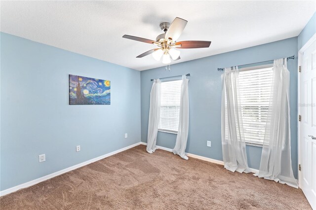 spare room with ceiling fan and carpet floors