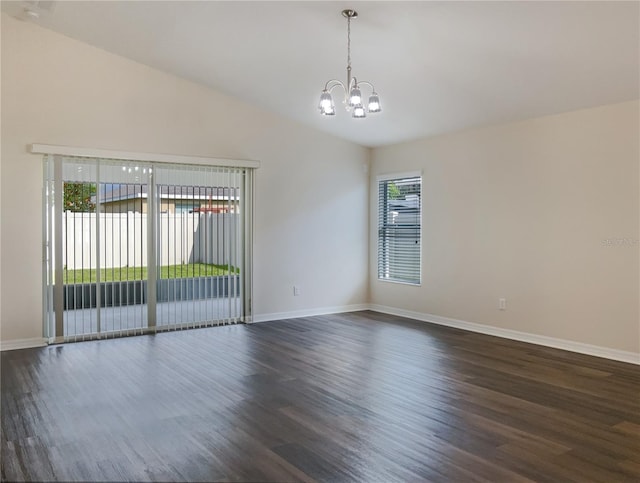 empty room with dark hardwood / wood-style floors, lofted ceiling, and a chandelier