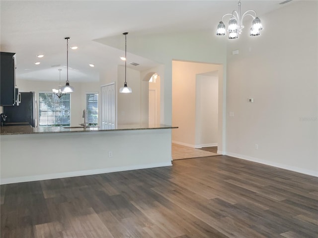 kitchen with lofted ceiling, dark wood-style flooring, hanging light fixtures, and an inviting chandelier