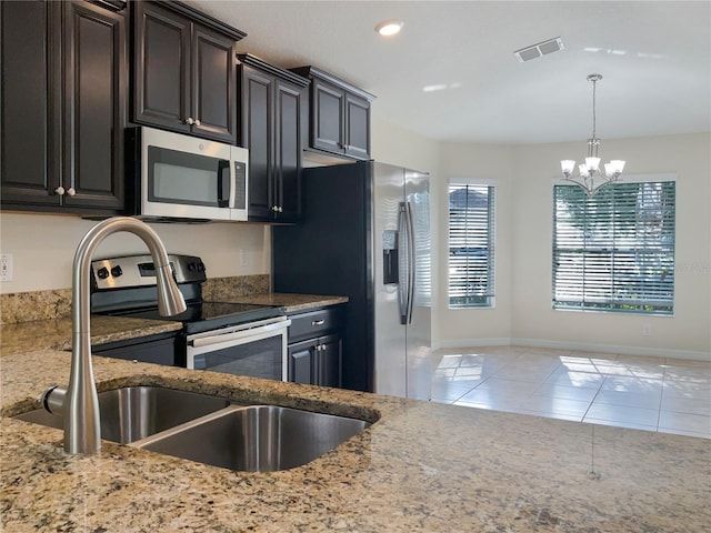 kitchen featuring light tile patterned floors, visible vents, appliances with stainless steel finishes, light stone counters, and pendant lighting