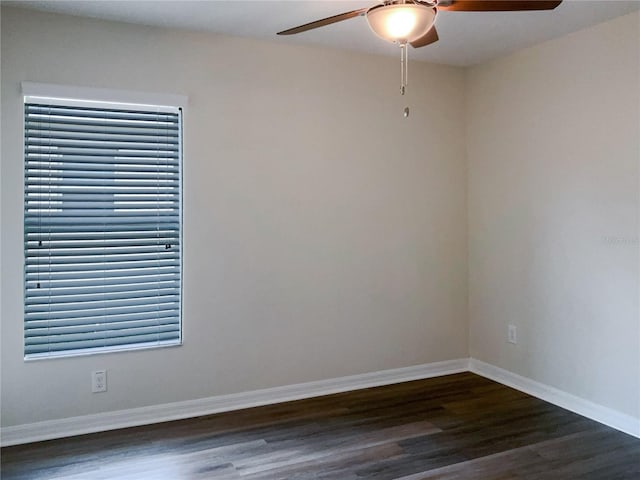 empty room featuring ceiling fan, baseboards, and dark wood finished floors