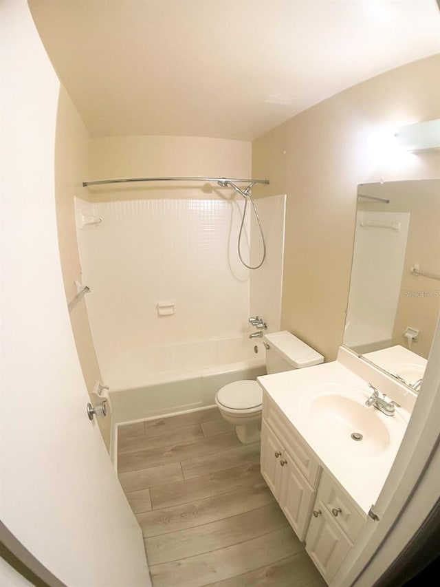 full bathroom with vanity, wood-type flooring, washtub / shower combination, and toilet