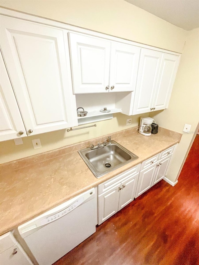 kitchen with sink, dark hardwood / wood-style floors, white cabinets, and white dishwasher