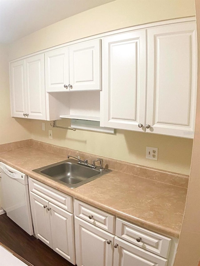 kitchen with dark hardwood / wood-style floors, white dishwasher, sink, and white cabinetry