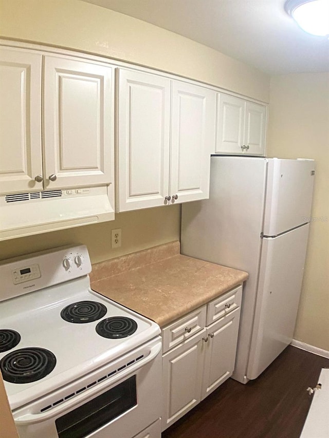 kitchen featuring white cabinets, dark wood-type flooring, and white appliances