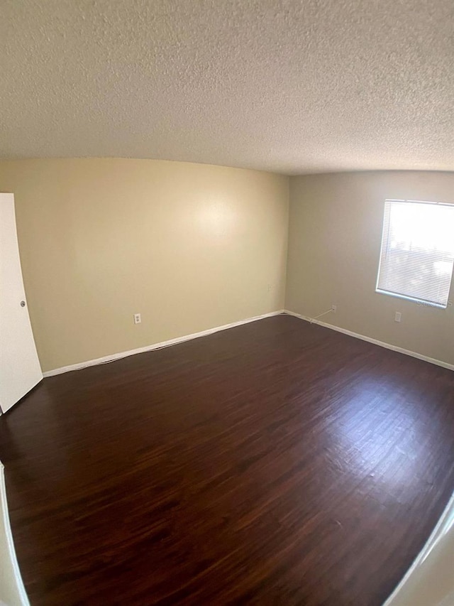 4335 Aegean Dr Unit 106A, Tampa, FL 33611 - unfurnished room with dark wood-type flooring, a textured ceiling, and baseboards
