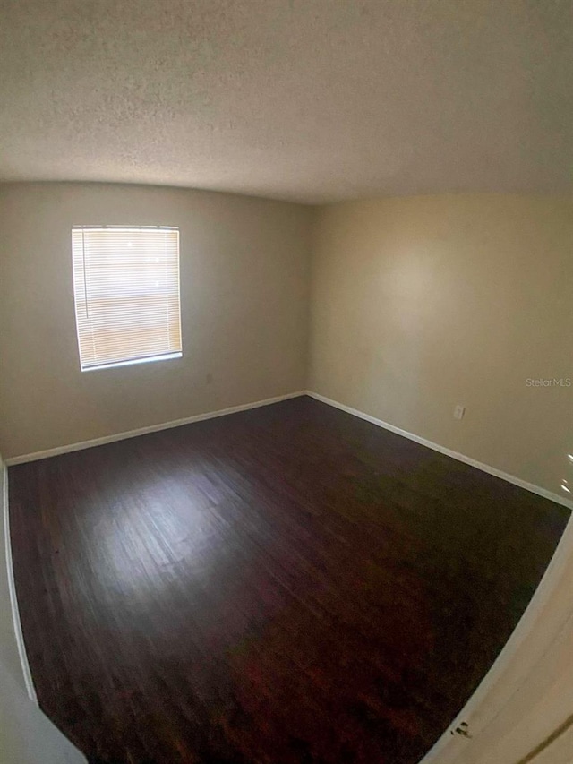 spare room featuring a textured ceiling and hardwood / wood-style floors