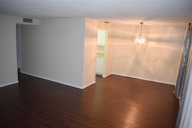 unfurnished room with dark hardwood / wood-style floors and a textured ceiling