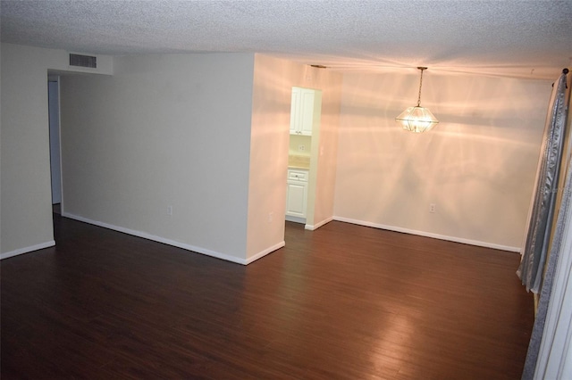 4335 Aegean Dr Unit 106A, Tampa, FL 33611 - spare room with dark wood-type flooring, a textured ceiling, and baseboards