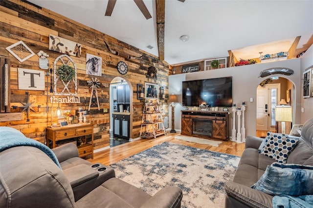 living room featuring wood walls, light wood-type flooring, and ceiling fan