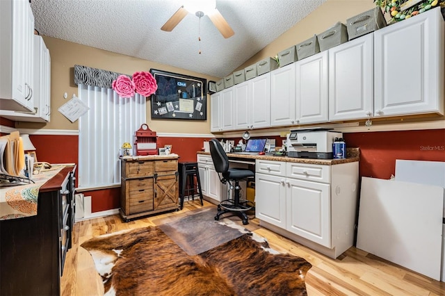 office space featuring ceiling fan, light hardwood / wood-style floors, a textured ceiling, and lofted ceiling