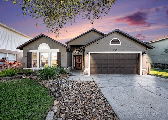 single story home featuring driveway, a garage, and stucco siding