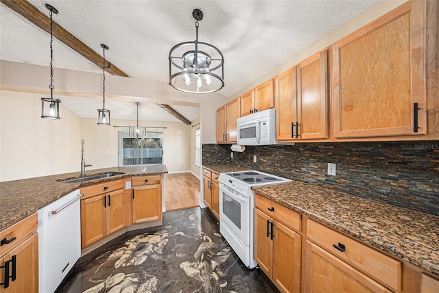 kitchen with white appliances, a sink, backsplash, dark stone counters, and decorative light fixtures