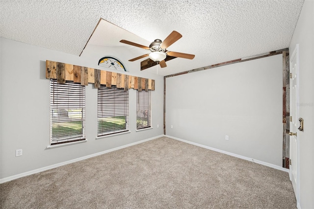 carpeted spare room with a textured ceiling, lofted ceiling, a ceiling fan, and baseboards